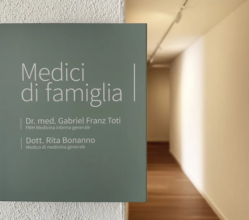 Insegna dei medici di famiglia con i nomi del Dr. med. Gabriel Franz Toti e della Dott. Rita Bonanno.