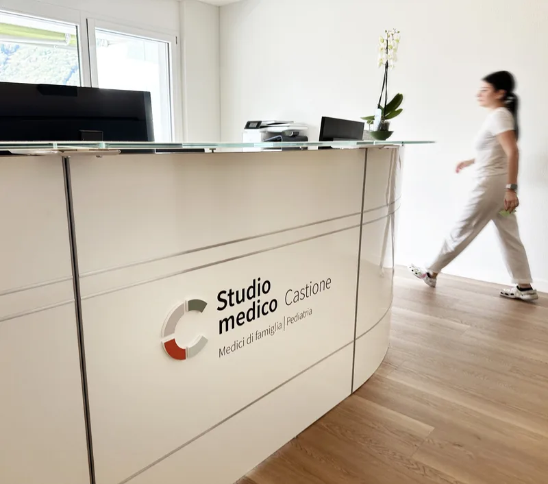 Un’assistente di studio passa accanto al bancone della reception.