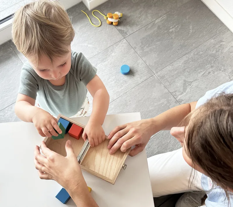 Un bambino gioca con blocchi di legno durante una visita pediatrica.